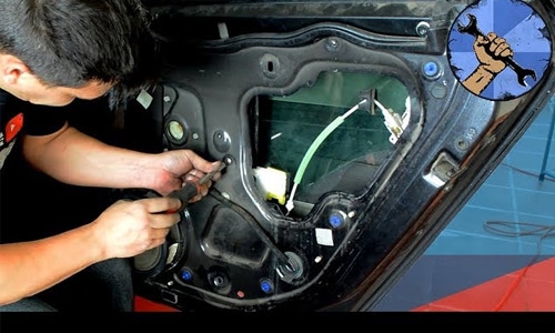 Reparación del mecanismo elevalunas en la puerta de un auto